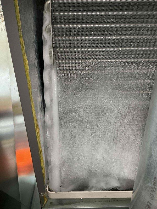 Responded to no cooling complaint on 2-year-old unit that had been off for 6 hours. Upon arrival, found evaporator coil completely frozen with heavy ice and frost buildup covering lower two-thirds of coil assembly. Identified restricted airflow as root cause of freeze condition. Shut down system to allow complete ice melt, inspected and replaced dirty air filter that was blocking airflow to evaporator coil. Verified all supply registers were open and unobstructed. Once coil fully defrosted, restarted system and monitored operation through complete cooling cycle. Confirmed proper airflow across coil, adequate temperature split, and normal system operation with no further icing. Advised on importance of regular filter maintenance to prevent future freeze-ups.