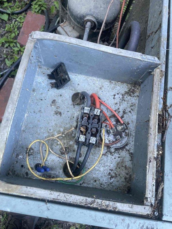 Responded to no cooling complaint on 10+ year old outdoor unit located on backside of property. Upon arrival, performed electrical diagnostics using multimeter and measured 61.2 volts at contactor, indicating failed contactor preventing compressor from receiving proper power supply. Inspected electrical disconnect box which showed significant corrosion, debris accumulation, and deteriorated wiring connections. Identified failed contactor as root cause of no cooling condition. Presented repair options to restore cooling operation.