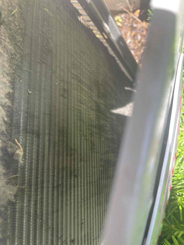 Completed cooling system tune-up on 13-year-old outdoor AC unit. Inspected and replaced dirty air filter, cleaned condenser coil fins which had accumulated significant debris and organic material between the fins affecting heat transfer efficiency. System operational upon completion of preventative maintenance service.