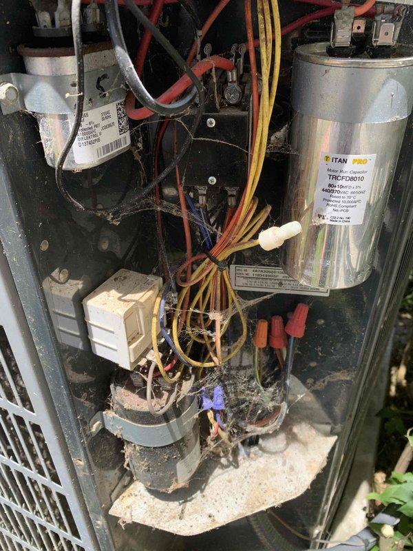 Completed preventative maintenance tune-up on outdoor condensing unit located at side of home. Upon inspection, found significant accumulation of dirt, dust, and debris throughout electrical compartment and on internal components. Performed thorough cleaning of condenser coil, checked all electrical connections, tested TITAN PRO capacitor for proper microfarad reading and voltage, inspected contactor operation, and verified compressor amperage draw. All wiring connections secured and system returned to normal operating condition with satisfactory cooling performance.
