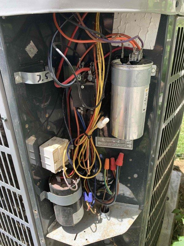 Completed preventative maintenance tune-up on outdoor condensing unit located at side of home. Upon inspection, found significant accumulation of dirt, dust, and debris throughout electrical compartment and on internal components. Performed thorough cleaning of condenser coil, checked all electrical connections, tested TITAN PRO capacitor for proper microfarad reading and voltage, inspected contactor operation, and verified compressor amperage draw. All wiring connections secured and system returned to normal operating condition with satisfactory cooling performance.