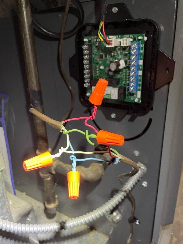 Responded to no-cool call on recently installed residential air conditioning system with thermostat power loss issue. Upon arrival, inspected thermostat wiring and traced low-voltage circuit back to outdoor condensing unit control board. Found loose wire connections at control board terminal blocks and improperly secured low-voltage wiring causing intermittent power loss to thermostat. Removed control board cover, inspected circuit board for damage, and identified multiple wire connections requiring proper termination. Re-landed all low-voltage wiring to appropriate terminals on control board, secured connections at blue terminal blocks, and verified proper wire routing through conduit. Tested thermostat power with multimeter and confirmed stable 24VAC supply. Reinstalled control board cover, cycled system through complete cooling operation, and verified thermostat maintained power throughout multiple on/off cycles. System operating normally with no further power interruptions detected