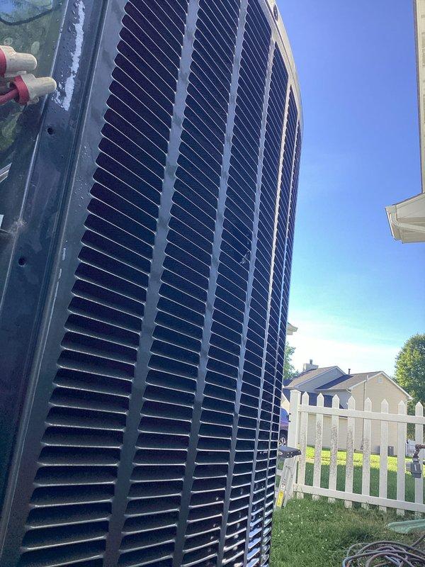 Completed comprehensive AC tune-up on single outdoor condensing unit located in side yard. Performed refrigerant pressure and temperature diagnostics using digital manifold gauge, with readings indicating system operating within normal parameters. Inspected cylindrical condenser unit with vertical slat grilles, verified proper airflow through louvers, and confirmed unit functionality during service visit.