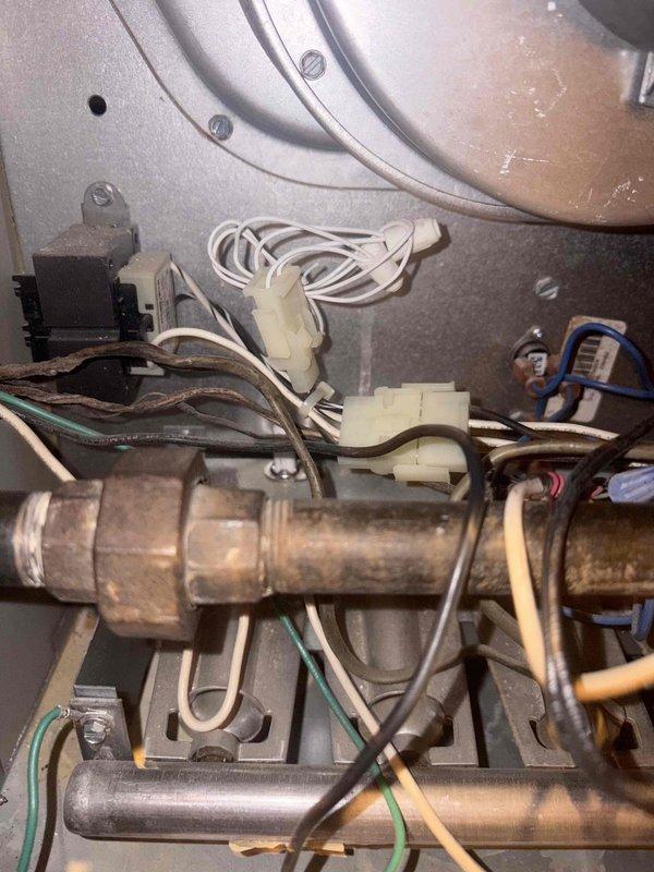 Responded to service call for furnace with blower motor activating prematurely upon system startup. Arrived at property after 3pm per customer request and provided 30-minute advance notice. Accessed basement unit (10+ years old) and performed diagnostic inspection of internal mechanical and electrical components. Examined gas valve assembly, electrical connections, control wiring, and blower motor circuitry. Identified loose electrical connectors and inspected thermostat control circuit for potential wiring issues causing premature blower activation. Documented internal component conditions including gas valve, wiring harnesses, and electrical junction points through photographic evidence for service records.