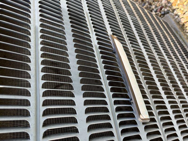 Completed preventive maintenance tune-up on a 12-year-old outdoor air conditioning unit. Performed comprehensive system inspection, cleaned condenser coils and fins, verified proper airflow through top discharge grille, and documented unit condition with photographs. All components found to be accessible and in serviceable condition for continued operation.