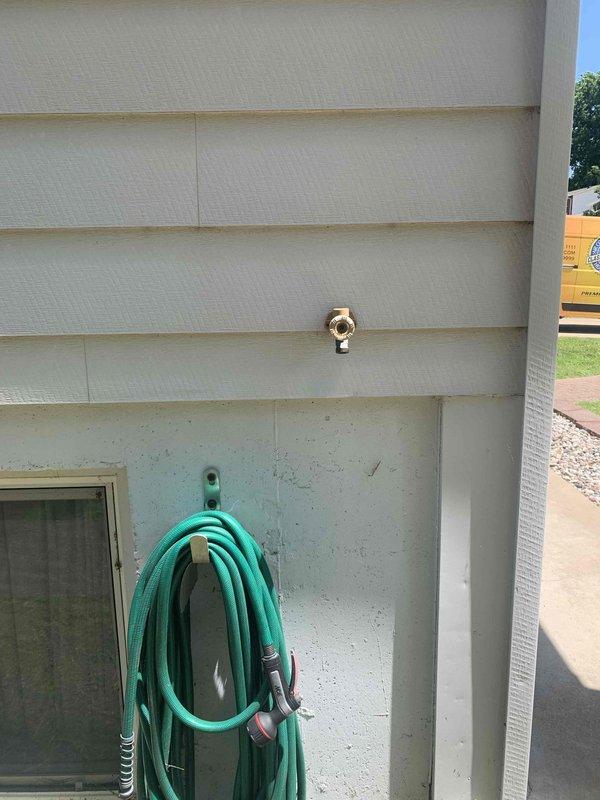 Returned to property to replace exterior hose bib as previously estimated. Successfully removed old brass hose bib from exterior wall and installed new unit, ensuring proper seal against vinyl siding to prevent water intrusion. While on site, also addressed reported clogged drain issue in basement by inspecting the drainage system and plumbing fixtures. Verified proper operation of all valves and connections in basement plumbing system, including blue-handled shutoff valve and associated piping mounted on wooden support beam. All work completed successfully with systems tested and functioning properly.