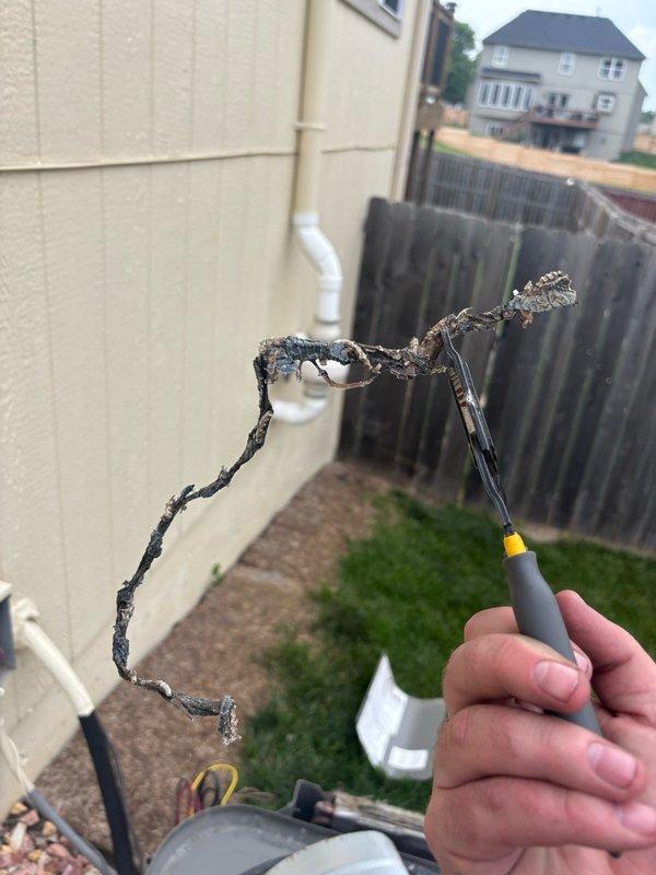 Responded to service call for reported obstruction in air conditioning system at residential property. Upon inspection of 10-year-old outdoor condenser unit located on side of home, discovered severely damaged and charred electrical wiring with complete insulation failure and exposed conductors. Wire exhibited significant heat damage and electrical burning, indicating dangerous fault condition. Removed compromised wiring, replaced with proper gauge conductor, and restored electrical connections to manufacturer specifications. Verified unit operation, tested electrical draws, and confirmed system functionality. Unit now operating safely with no further obstructions or electrical hazards present.
