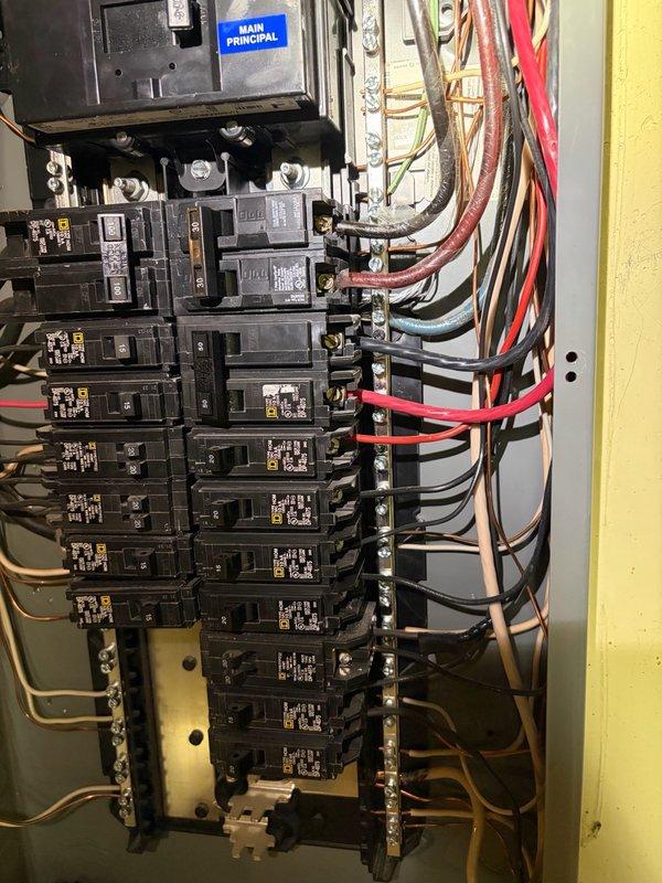 Completed electrical assessment for car charging station installation at service panel. Evaluated existing main circuit breaker panel capacity, bus bar configuration, and available breaker positions to determine feasibility of adding dedicated EV charger circuit. Documented current electrical infrastructure including main disconnect breaker, circuit distribution, wire routing, and grounding system. Assessed panel for adequate amperage capacity and physical space to accommodate new high-amperage circuit required for Level 2 electric vehicle charging equipment. Photographed panel interior showing existing circuit breaker layout, wire management, and service entrance configuration to support estimate preparation.