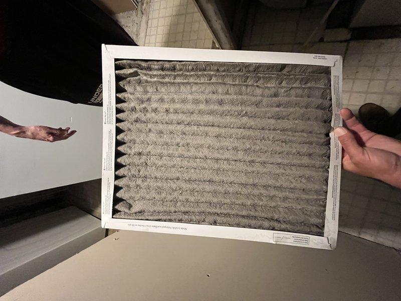 Responded to no cooling complaint on 20-year-old air conditioning system located in back area near basement furnace. Upon inspection, found severely clogged air filter restricting airflow and excessive condensation on evaporator coil assembly. Replaced dirty air filter and addressed moisture accumulation issues affecting system performance. System restored to proper cooling operation.