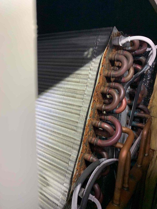 Responded to no cooling complaint on 10-year-old Lennox air conditioning system. Upon inspection, discovered severely corroded evaporator coil with significant oxidation on copper refrigerant tubes and rust deterioration along coil casing edges. The extensive corrosion on the coil assembly and connecting components indicated long-term moisture exposure and end-of-service-life condition. Documented coil condition with photographs showing advanced deterioration of copper tubing, aluminum fins, and mounting brackets. Advised customer that evaporator coil replacement is necessary to restore cooling function, as the current coil's compromised integrity is preventing proper heat exchange and refrigerant flow.