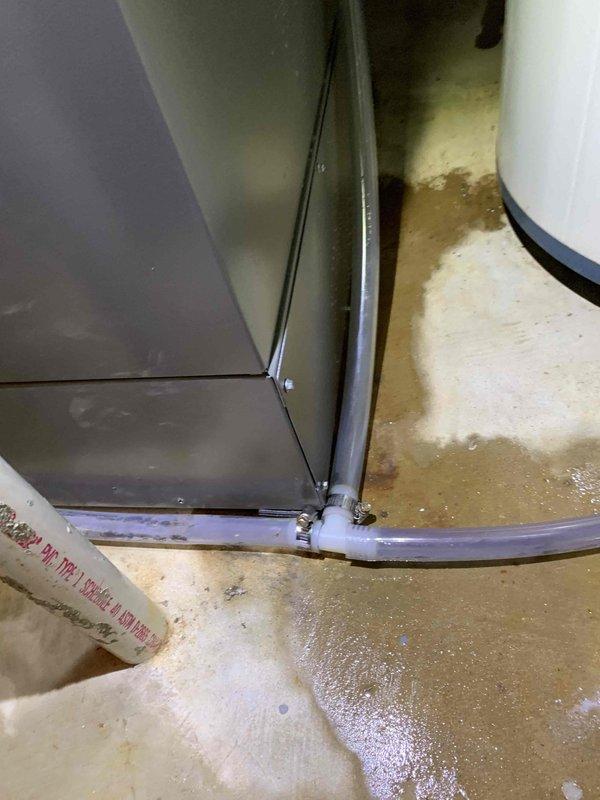 Responded to reported humidifier leak in basement. Upon arrival, found significant water pooling around base of HVAC unit and evidence of ongoing water discharge onto concrete floor. Inspected humidifier system and associated drainage components, identifying failed or disconnected drain line as source of water accumulation. Observed water damage and staining on floor surface indicating prolonged moisture exposure. Repaired drainage issue, secured all connections, and verified proper water flow through condensate system. Tested humidifier operation to confirm leak was resolved and unit was functioning correctly without further water discharge.