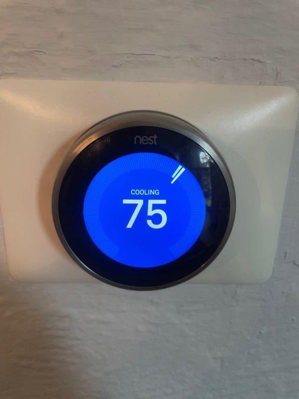 Responded to report of air conditioning system not cooling properly overnight with Nest thermostat not blowing cold air. Upon arrival, system was operational and cooling effectively to setpoint of 75°F. Performed diagnostic inspection of indoor air handler, examining blower wheel assembly for potential airflow restrictions or mechanical issues. Verified proper system operation, confirmed adequate airflow through blower assembly, and documented thermostat functioning correctly in cooling mode at time of service.