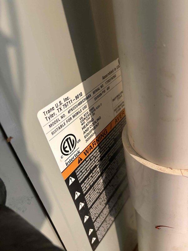 Responded to no cooling complaint on 15-year-old Trane air conditioning system. Upon inspection, found severely inadequate temperature split of -1 degree across evaporator coil, well below the ideal 18-21 degree range. Discovered frozen evaporator coil obstructing accurate temperature readings and active water accumulation around and inside the air handler unit during cooling cycle. Documented equipment conditions including model TX 7E-5711-D010 specifications and installation environment. System requires comprehensive service to address restricted airflow or refrigerant issues causing coil freeze-up and inadequate heat transfer, restoring proper cooling capacity and eliminating water intrusion concerns.