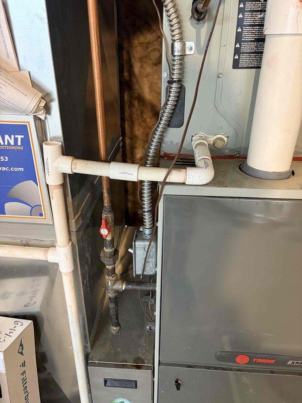 Responded to no cooling complaint on 15-year-old Trane air conditioning system. Upon inspection, found severely inadequate temperature split of -1 degree across evaporator coil, well below the ideal 18-21 degree range. Discovered frozen evaporator coil obstructing accurate temperature readings and active water accumulation around and inside the air handler unit during cooling cycle. Documented equipment conditions including model TX 7E-5711-D010 specifications and installation environment. System requires comprehensive service to address restricted airflow or refrigerant issues causing coil freeze-up and inadequate heat transfer, restoring proper cooling capacity and eliminating water intrusion concerns.