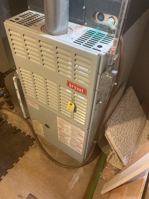 # HVAC Service Report: No Cooling Condition

Responded to service call for air conditioning system experiencing freeze-up condition at outdoor unit with complete loss of cooling capacity. Issue reportedly began over the weekend. System is approximately 25 years old and nearing end of expected service life.

Upon arrival, conducted comprehensive diagnostic evaluation of the split system air conditioner. Inspected outdoor condensing unit and found evidence of ice accumulation on refrigerant lines and coil surfaces, consistent with reported symptoms. Documented equipment condition through photographic evidence showing existing Bryant furnace installation and associated ductwork infrastructure in basement mechanical space.

Performed systematic troubleshooting to identify root cause of freezing condition. Common causes for AC freeze-up include restricted airflow due to dirty air filters, blocked evaporator coils, low refrigerant charge from leak, failed blower motor operation, or collapsed