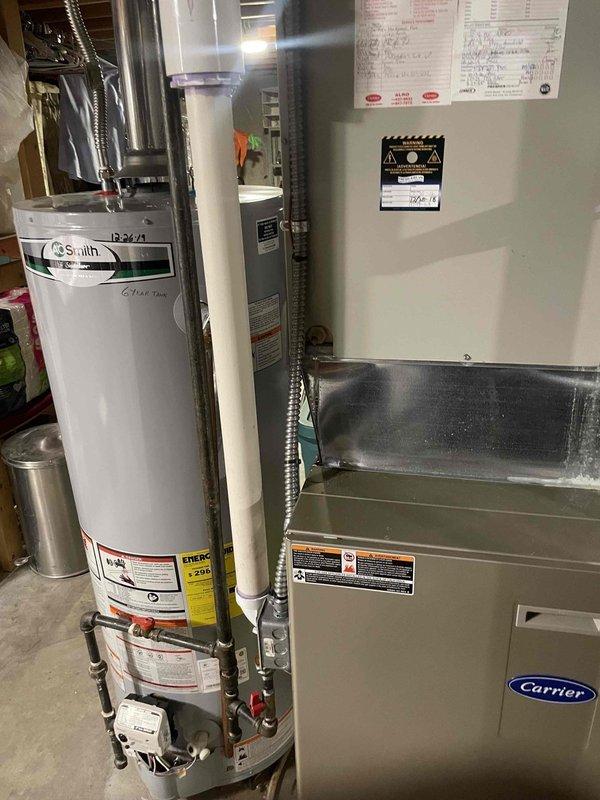 Responded to report of water leaking from HVAC unit in basement. Upon arrival, inspected over 10-year-old Carrier furnace/air handler and adjacent A.O. Smith water heater for source of reported leak. Conducted thorough visual examination of equipment, plumbing connections, condensate drain system, and surrounding utility room area. Documented existing conditions of both heating systems and associated piping infrastructure with photographs for service records.