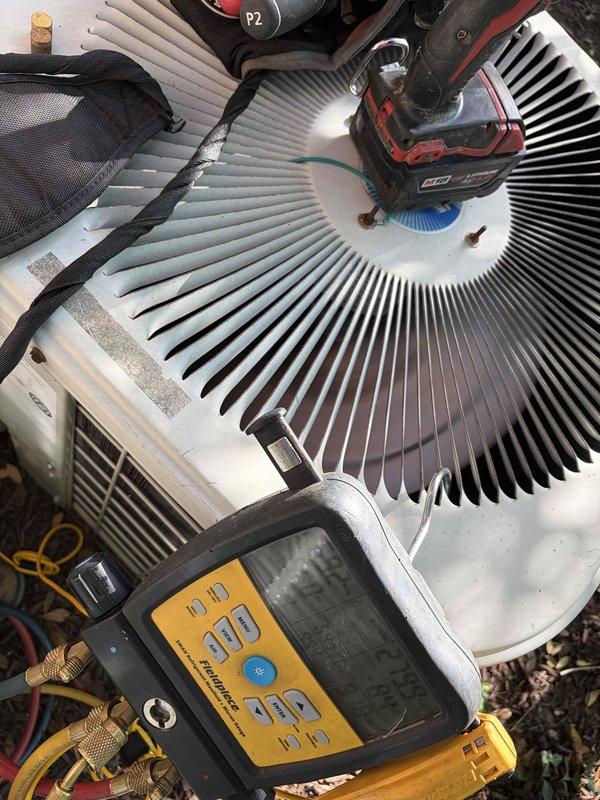 Responded to service call for condensation issue on flue liner at property with three HVAC units, all approximately four years old. Upon arrival, performed diagnostic assessment of the affected system using digital manifold gauges to check refrigerant pressures and system performance. Inspection revealed significant condensation accumulation on ductwork in mechanical space, with visible moisture patterns on the main supply plenum and surrounding components. Examined outdoor condensing unit and verified proper fan operation and airflow through coil assembly. Documented conditions with photos showing moisture buildup on interior ductwork and exterior unit configuration during testing. Identified condensation concern related to inadequate insulation or air sealing on cold surfaces in unconditioned space. Provided customer with findings and recommendations for addressing moisture infiltration to prevent ongoing condensation issues and potential water damage.