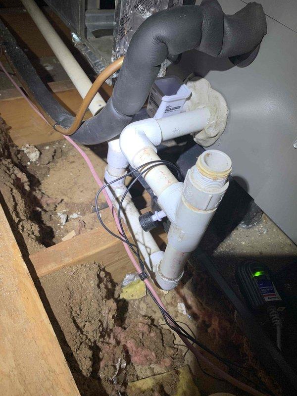Arrived on-site for scheduled service call but job was cancelled after dispatch. Documented existing HVAC system configuration including air handler unit with horizontal slat panels and vertical louvers, along with associated PVC condensate drain piping assembly featuring multiple elbows, foam pipe insulation, and flexible discharge line in utility area. No work performed due to cancellation.