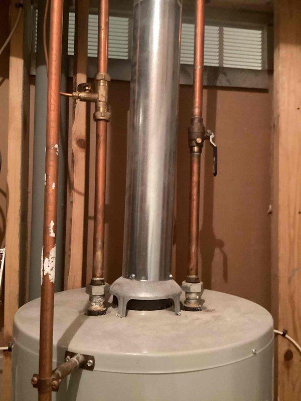 Replaced leaking 40-gallon gas water heater with new tall tank unit due to failure at drain spigot and suspected internal tank leaks. Completed full installation including copper piping connections, pressure relief valve, shut-off valves, and metallic flue pipe venting system in accordance with permit #26plu-11425. Applied required plumbing identification sticker to completed installation.