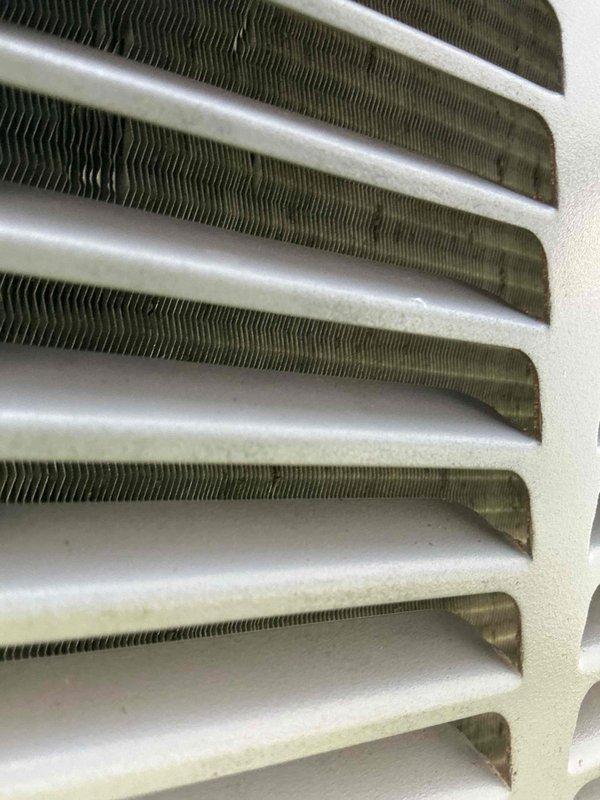 Performed comprehensive tune-up maintenance on outdoor condensing unit with unit number F58697093. Condenser coils exhibited significant accumulation of dirt, dust, and debris on exterior panels and fins, requiring thorough cleaning to restore proper airflow and heat transfer efficiency. Cleaned evaporator coil assembly, which showed multiple horizontal fin rows in satisfactory condition with minor discoloration. System operational following maintenance procedures.