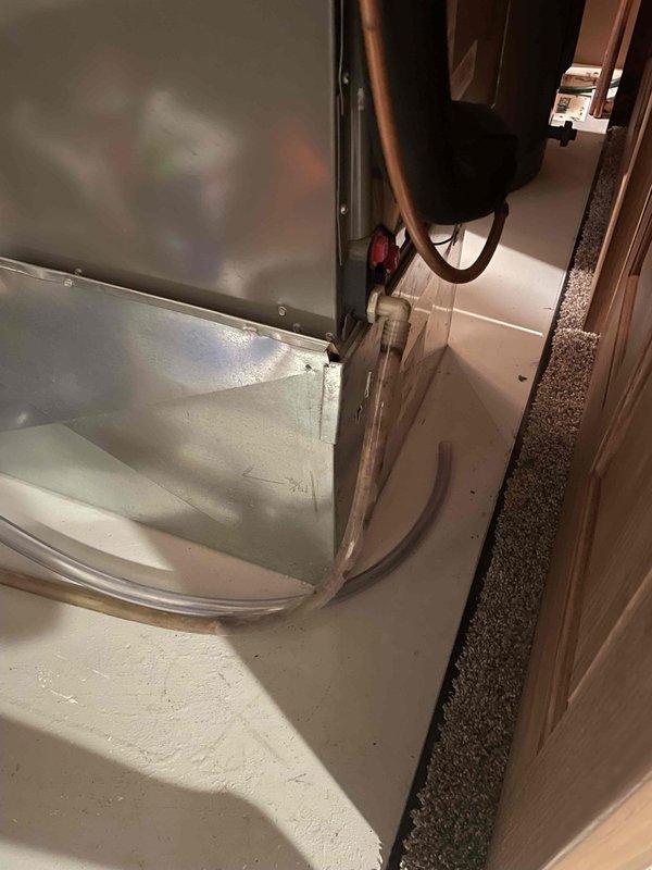 Responded to water leak issue affecting indoor air handler unit. Upon inspection, found condensate drainage line improperly routed, causing water to drain onto the return air filter. Cleared existing blockage from drain line, repositioned and secured drainage tubing with proper clips to ensure gravity flow to designated drain point. Verified condensate pump operation and confirmed no water accumulation in drain pan. System tested and operating without leaks.