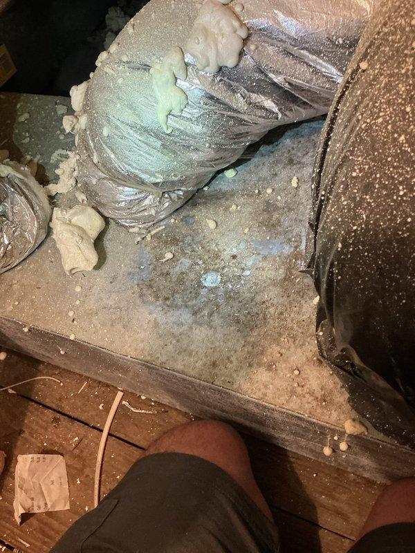 Responded to service call for attic-mounted air conditioning system experiencing refrigerant leak causing water damage to ceiling below. Upon inspection, located evaporator coil with active leak at copper tubing connections. Found condensate drain line partially obstructed, contributing to overflow condition. Documented equipment condition and leak source with photographs showing evaporator coil assembly, ductwork installation, and surrounding insulation damage. Identified 9-year-old system requiring immediate repair to prevent further structural damage. Provided assessment and repair recommendations to address refrigerant leak and drainage issues.