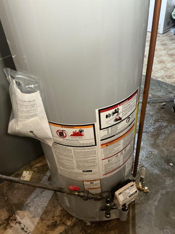 Installed a 40-gallon tall gas water heater in residential basement utility area with complete copper piping connections and safety labeling. Completed full system installation including hot water distribution network with proper venting and code-compliant plumbing connections. Applied required permit identification sticker per permit #26plu-11538 and verified all safety labels and technical specifications are properly displayed on unit.