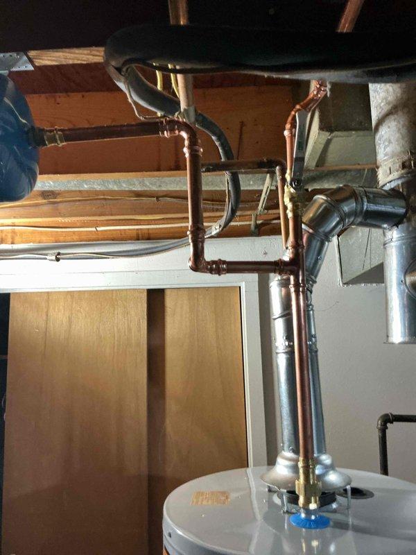 Installed a 40-gallon tall gas water heater in residential basement utility area with complete copper piping connections and safety labeling. Completed full system installation including hot water distribution network with proper venting and code-compliant plumbing connections. Applied required permit identification sticker per permit #26plu-11538 and verified all safety labels and technical specifications are properly displayed on unit.