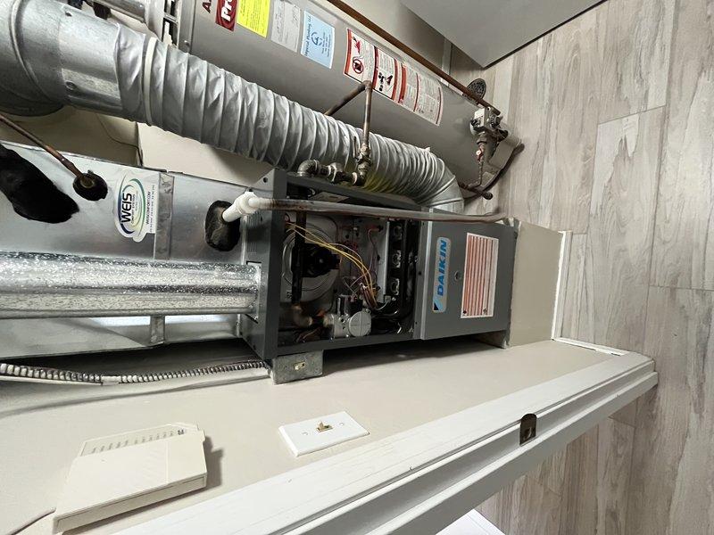 Responded to service call for air conditioning system operating with excessive noise levels. Upon arrival, performed comprehensive inspection of Daikin HVAC system including air handler unit and associated ductwork in mechanical room. Evaluated system components, flexible ductwork connections, and condensate management. Documented equipment condition with photographs showing proper installation of air handler, ductwork configuration, and moisture accumulation on metallic duct sections. Advised customer on system operation and recommended unit shutdown until further assessment could be completed to prevent potential component damage from continued operation under current conditions.