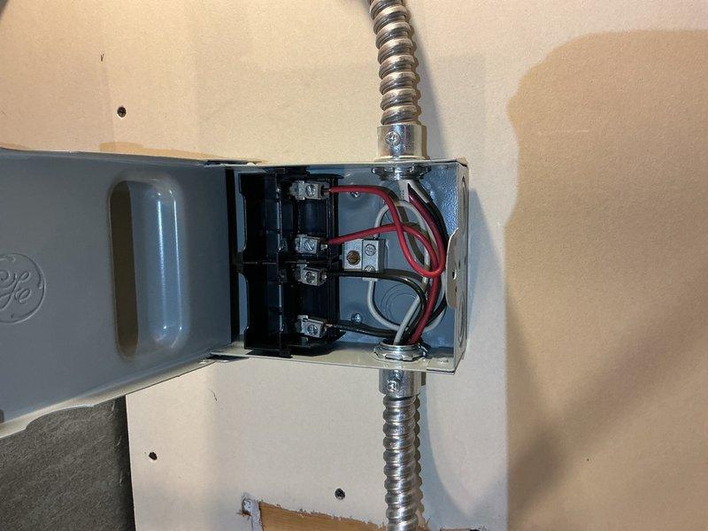 Responded to service call for newly installed water heater with no power. Inspected electrical service entrance at exterior meter base and traced wiring through conduit system to interior junction box. Examined connections at junction box where flex conduit supplies power circuit to water heater location. Verified proper wire terminations at terminal blocks and assessed circuit integrity from main panel through distribution point. Documented electrical infrastructure including meter socket, service disconnect, and branch circuit wiring configuration to determine cause of power failure to new water heater installation.