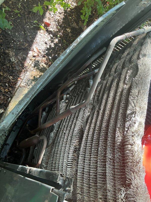 Responded to no cooling complaint on 10+ year old outdoor condenser unit located in backyard. Upon arrival, found unit operational but with severely restricted airflow due to heavy accumulation of dirt, dust, and debris coating exterior surfaces and condenser coils. Observed frost buildup on evaporator coil, indicating restricted airflow and reduced heat transfer efficiency. Documented existing conditions with photographs showing deteriorated exterior casing and contaminated coil surfaces. Diagnosed primary issue as inadequate system maintenance resulting in diminished cooling capacity and potential refrigerant circuit complications from extended operation under restricted conditions.