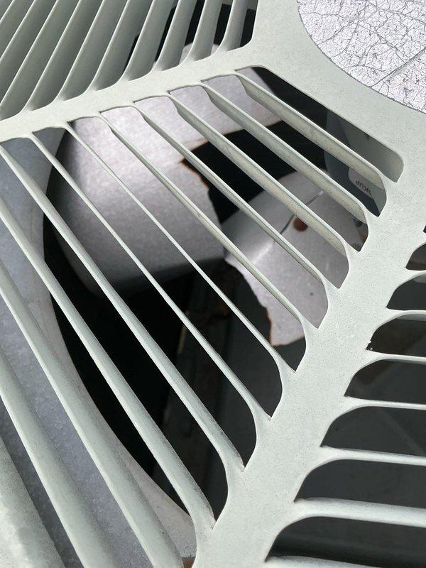 Responded to no-cooling complaint with unit running continuously and unable to maintain temperature setpoint, reaching only 80°F despite thermostat set to 69°F. Upon arrival, performed visual inspection of ground-level condensing unit located in garage area. Documented exterior condition of equipment showing mint green painted cabinet with intact louvered panels and ventilation grilles in satisfactory condition, with foam insulation visible through openings and no apparent physical damage or deterioration to housing components.