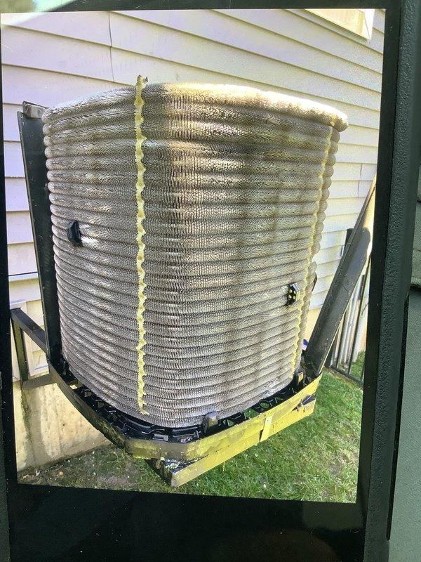 Responded to customer complaint of upstairs AC unit running continuously without adequate cooling. Performed diagnostic evaluation on 9-year-old residential air conditioning system. Inspected outdoor condenser unit, noting dirt and debris accumulation on coil fins affecting heat transfer efficiency. Examined indoor air handler components including filter housing and ductwork. Documented system condition with photographic evidence showing weathered condenser coils with visible contamination and standard filter installation. System assessed for potential airflow restrictions and refrigerant performance issues common in units of this age and condition.