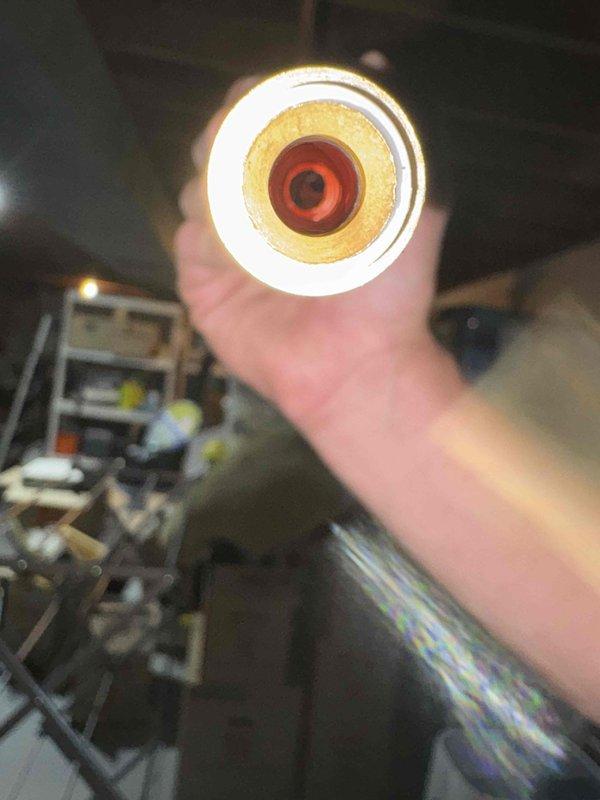 Pumped system down and inspected piston assembly due to diminished cooling performance. Upon inspection, discovered deteriorated insulation and compromised refrigerant line component. Documented condition with photos showing cross-section of damaged pipe revealing degraded insulation layers and inner line corrosion. System requires repair to restore proper cooling capacity.