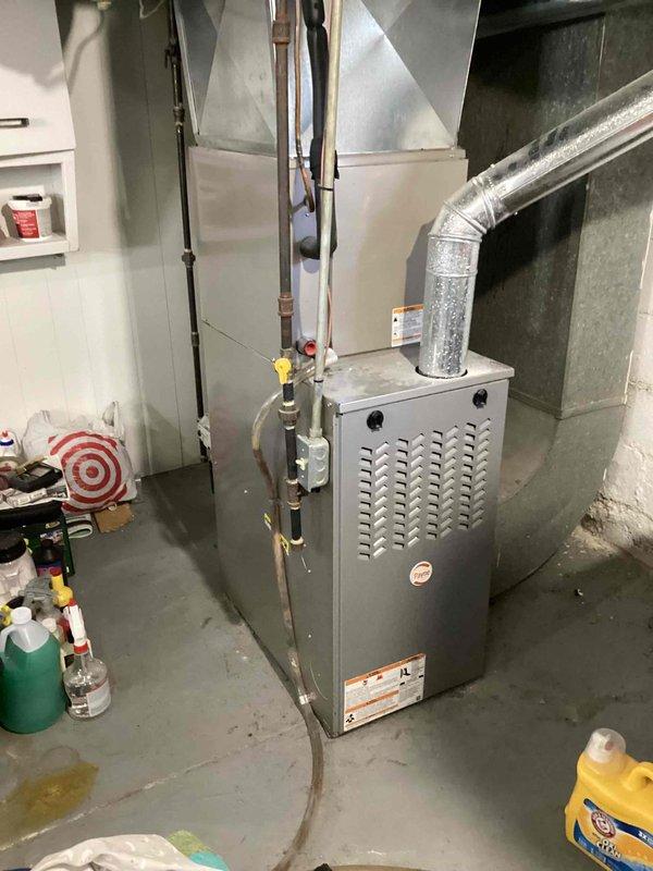 Responded to no cooling complaint on residential air conditioning system less than 10 years old located in side yard. Customer reported unit blowing warm air. Upon arrival, advised customer to turn system off to prevent further damage. Performed diagnostic evaluation of outdoor condensing unit and indoor air handler components. Inspected furnace and associated ductwork in basement mechanical room. Documented equipment conditions including HVAC system installation, copper refrigerant lines, and electrical connections. Identified root cause of cooling failure and provided repair recommendations to restore proper system operation.
