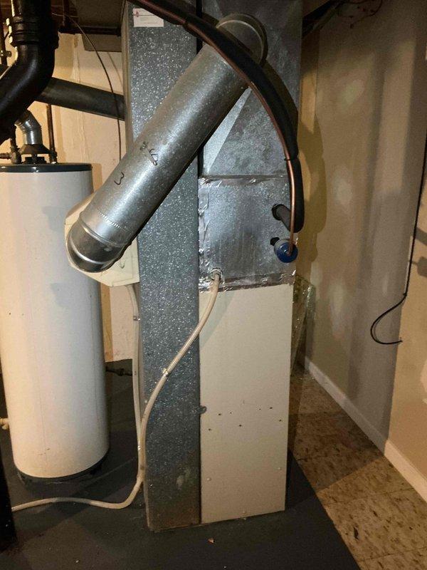 # HVAC Service Report - No Cool Air Complaint

Responded to service call for air conditioning system not producing cold air throughout residence. Upon arrival, performed comprehensive system diagnostic to identify root cause of cooling failure.

Conducted visual inspection of indoor furnace unit and associated HVAC components in basement mechanical room. Examined Plus 80 furnace with connected ductwork, humidifier system, and related plumbing connections. Verified proper electrical connections and assessed overall system configuration.

Proceeded to outdoor condensing unit to evaluate compressor operation, refrigerant levels, and electrical components. Checked capacitor functionality, contactor operation, and verified proper voltage supply to unit. Measured temperature differential across evaporator coil to determine cooling performance.

Identified issue preventing proper cooling operation and performed necessary repairs to restore system functionality. Tested system operation through