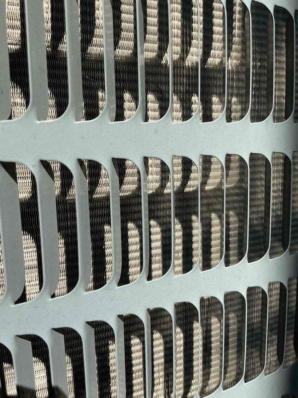 Completed comprehensive AC tune-up on 10-year-old condensing unit located in side yard requiring ladder access. Inspected and photographed condenser coil fins showing clean condition with proper spacing and no debris accumulation, confirmed adequate airflow through grille openings and heat exchanger surfaces maintaining optimal thermal transfer efficiency.