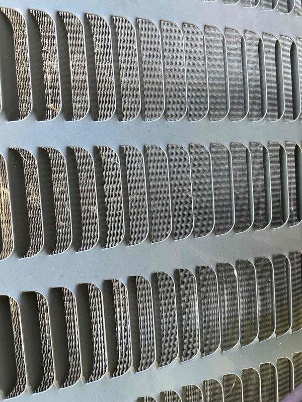 Completed comprehensive AC tune-up on 10-year-old condensing unit located in side yard requiring ladder access. Inspected and photographed condenser coil fins showing clean condition with proper spacing and no debris accumulation, confirmed adequate airflow through grille openings and heat exchanger surfaces maintaining optimal thermal transfer efficiency.