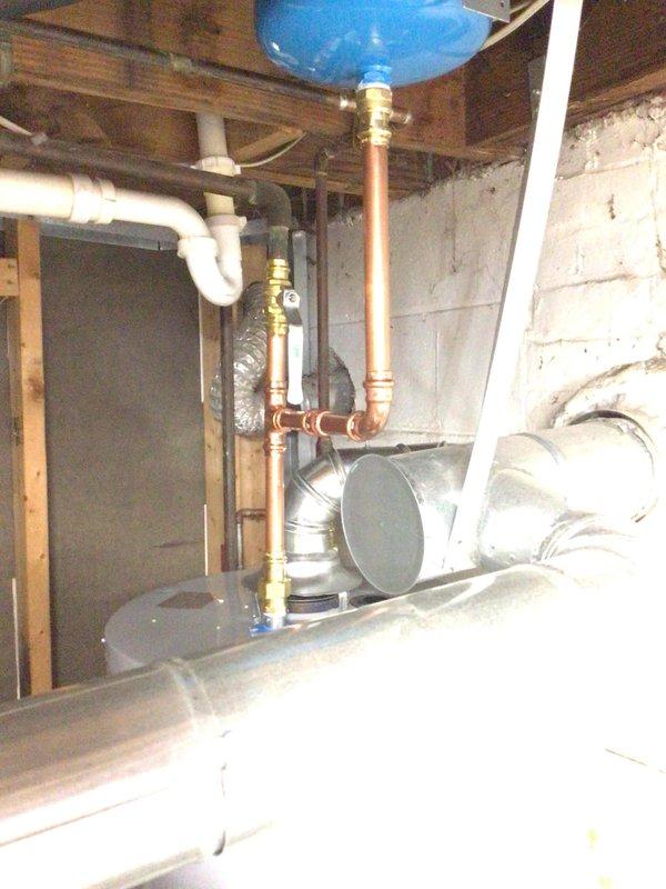 Installed 40-gallon tall gas water heater in basement utility area, replacing existing corroded unit. Completed all copper piping connections with brass fittings, integrated with existing PVC drainage and vent system, and connected HVAC ductwork for proper ventilation. Installation performed under permit #26PLU-11666 with plumbing ID sticker applied per code requirements.