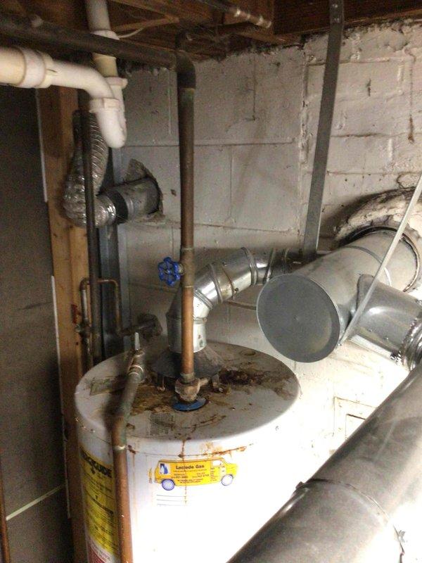 Installed 40-gallon tall gas water heater in basement utility area, replacing existing corroded unit. Completed all copper piping connections with brass fittings, integrated with existing PVC drainage and vent system, and connected HVAC ductwork for proper ventilation. Installation performed under permit #26PLU-11666 with plumbing ID sticker applied per code requirements.