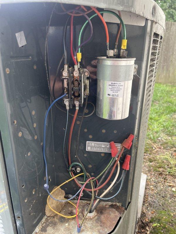Responded to no cooling complaint on 18-year-old Trane system unable to maintain 72°F setpoint, remaining at 78°F. Upon arrival, located outdoor condensing unit and removed access panel for inspection. Performed visual and electrical diagnostics on condenser components including contactor, capacitor, and wiring connections. Found failed dual run capacitor with visible signs of age-related deterioration and corrosion on internal components. Replaced defective capacitor with proper MFD-rated unit, verified all electrical connections secure, and tested contactor operation. Restored power to system and monitored startup sequence. Confirmed compressor and condenser fan motor energized properly with normal amperage draw. Verified refrigerant pressures within manufacturer specifications and system achieving proper temperature split across evaporator coil in basement air handler. System cycled normally and began pulling down indoor temperature effectively. Reinstalled condenser access panel an