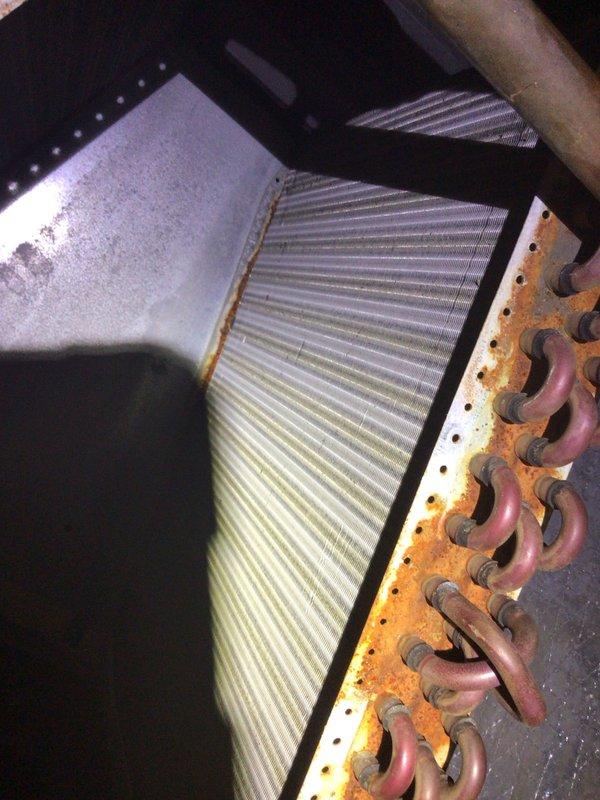 Responded to no-cooling callback on 10+ year old AC unit that had been shut off. Upon inspection, found evaporator coil with significant dirt accumulation and heavily corroded copper refrigerant lines showing orange-brown oxidation. Observed moisture and condensation patterns inside air handler indicating previous operational issues. Documented coil condition showing yellowish-brown discoloration on aluminum fins and rust-colored deterioration on copper tubing connections. System components showed signs of age-related wear and potential refrigerant circuit compromise due to copper line corrosion.