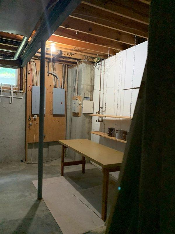 Completed electrical estimate for car charging station installation in unfinished basement area. Assessed existing electrical infrastructure including two main circuit breaker panels mounted on exposed studs to determine capacity and compatibility for EV charger integration. Evaluated available circuit breaker slots, main service amperage, and load calculations to ensure adequate power supply for Level 2 charging equipment. Documented current electrical panel configuration, wire routing paths along ceiling joists and walls, and optimal conduit runs from panels to proposed charging station location. Photographed existing electrical setup and basement layout for detailed estimate preparation.