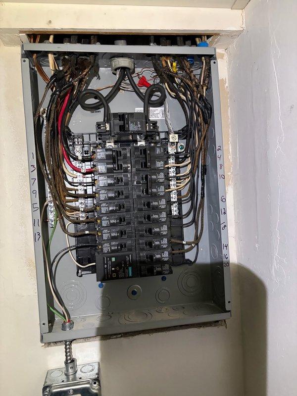Completed 200-amp electrical panel replacement at residential property. Removed existing outdated panel and installed new main breaker panel with properly organized circuit breaker configuration across two vertical columns. Terminated all branch circuit wiring with appropriate color-coded conductors, ensuring proper wire management and systematic routing throughout the enclosure. Panel installation includes proper grounding, secure mounting to interior wall, and all circuits tested for functionality upon completion.