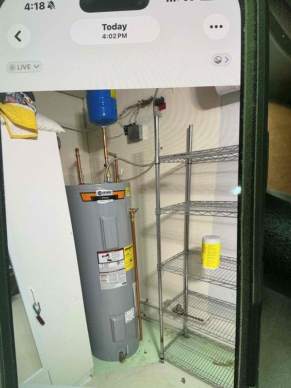 Completed installation of 50-gallon tall electric water heater in basement utility area. Unit was set up and prepared for delivery with all necessary plumbing connections, including copper piping, expansion tank, and flexible connectors properly installed per manufacturer specifications and local code requirements.