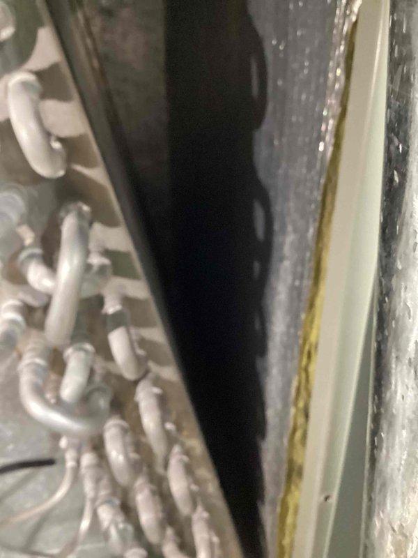 Performed inspection of 6-year-old ground-level air conditioning unit in response to customer concerns regarding potential mold contamination on coils and vents. Upon inspection, discovered significant biological growth and debris accumulation in the condensate drain pan, including yellowish-brown organic material and algae buildup concentrated around the drain connection point. Documented conditions with photographs showing contaminated drain pan with fibrous growth on surfaces and around PVC drain fitting. Inspected refrigerant lines, insulation, and air handler interior components for additional mold or moisture concerns.