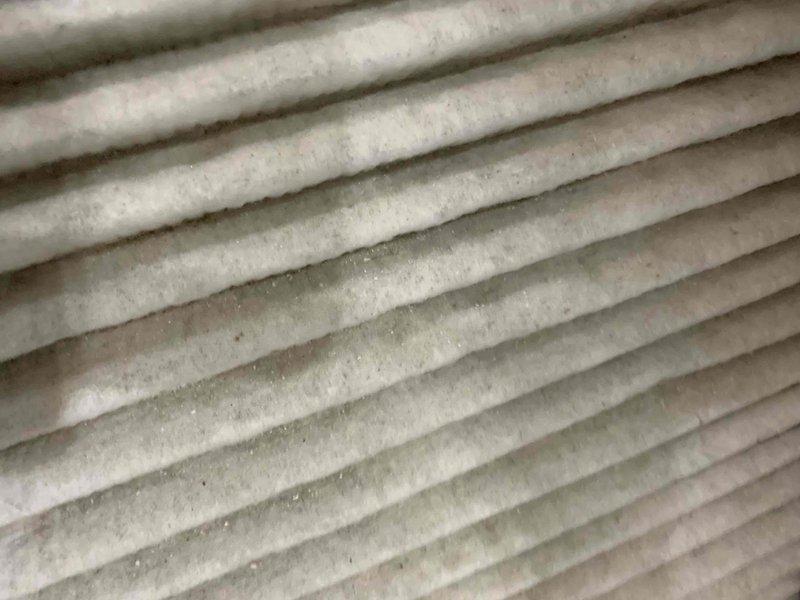 Completed cooling maintenance tune-up on a 9-year-old air conditioning system that was operating properly at time of service. Inspected and documented air filter showing moderate dust accumulation with light to moderate debris throughout pleated media, and exterior condenser coil exhibiting significant dirt and debris buildup restricting airflow, with concentrated patches of dust and environmental contaminants across the fin surfaces. Performed standard preventive maintenance procedures including system performance evaluation, component inspection, and cleaning as needed to restore optimal operating efficiency.