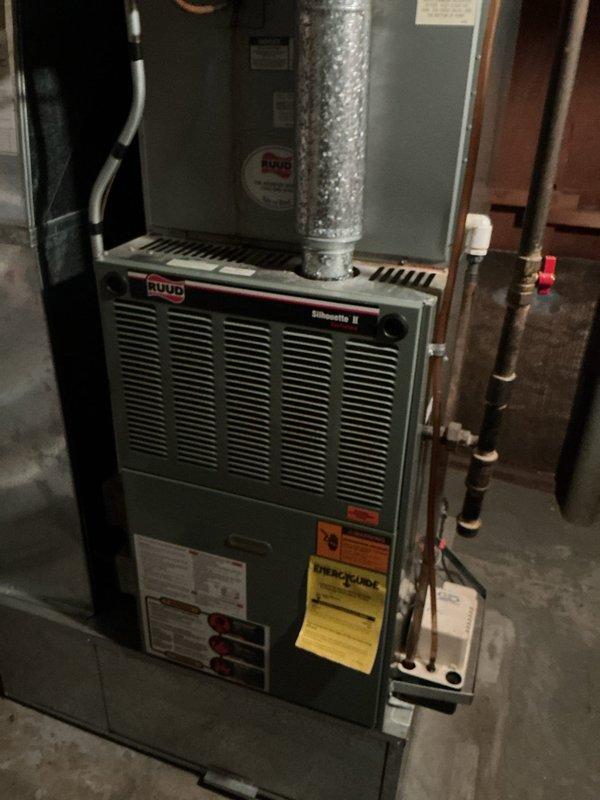 Responded to no cooling complaint on 10+ year old residential Bryant AC system located at side of home. Upon arrival, found thermostat display malfunctioning and unit failing to maintain proper cooling. Performed comprehensive diagnostic evaluation of both indoor Ruud Silhouette II furnace with air handler and outdoor Bryant condenser unit. Inspected electrical connections, refrigerant levels, and control systems. Documented equipment condition with photos showing both indoor and outdoor components. Identified issues preventing proper system operation and provided customer with repair recommendations to restore cooling functionality.