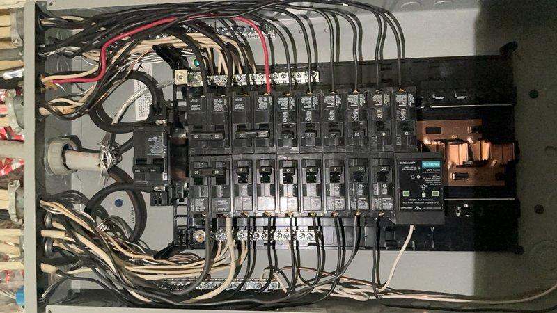 Completed electrical panel replacement, upgrading from existing service to new 100-amp main distribution panel. Removed old panel assembly and installed new panel enclosure with modern circuit breakers arranged in dual-column configuration. Terminated all existing branch circuit wiring to appropriate breaker positions, ensuring proper wire routing and secure connections to copper bus bars. All conductors were properly organized, bundled with appropriate fasteners, and connected in compliance with current electrical code requirements.