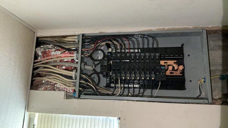 Completed electrical panel replacement, upgrading from existing service to new 100-amp main distribution panel. Removed old panel assembly and installed new panel enclosure with modern circuit breakers arranged in dual-column configuration. Terminated all existing branch circuit wiring to appropriate breaker positions, ensuring proper wire routing and secure connections to copper bus bars. All conductors were properly organized, bundled with appropriate fasteners, and connected in compliance with current electrical code requirements.